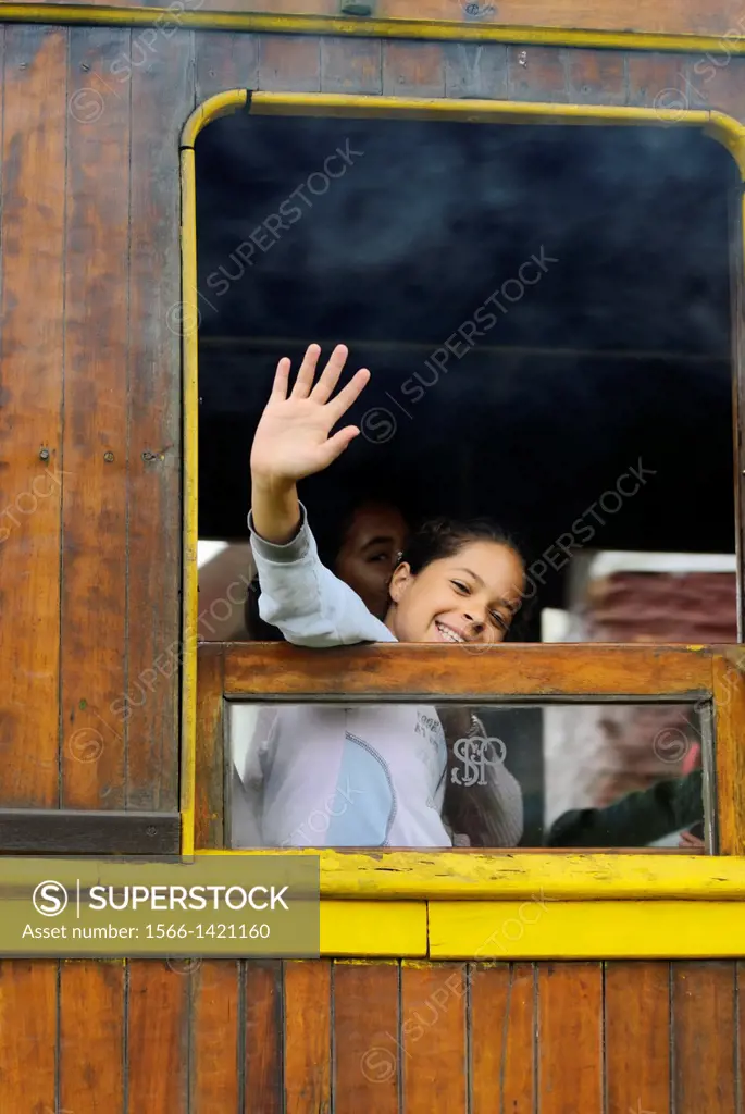 Loughing girl looking out of a historic steam train at Paranapiacaba station; near Sao Paulo, Brazil. In 1856 the British-owned Sao Paulo Railway Comp...