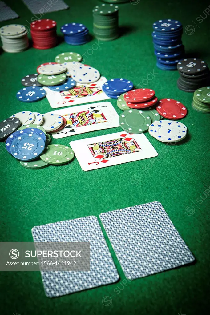 cards poker deck English, poker chips stack on green table.