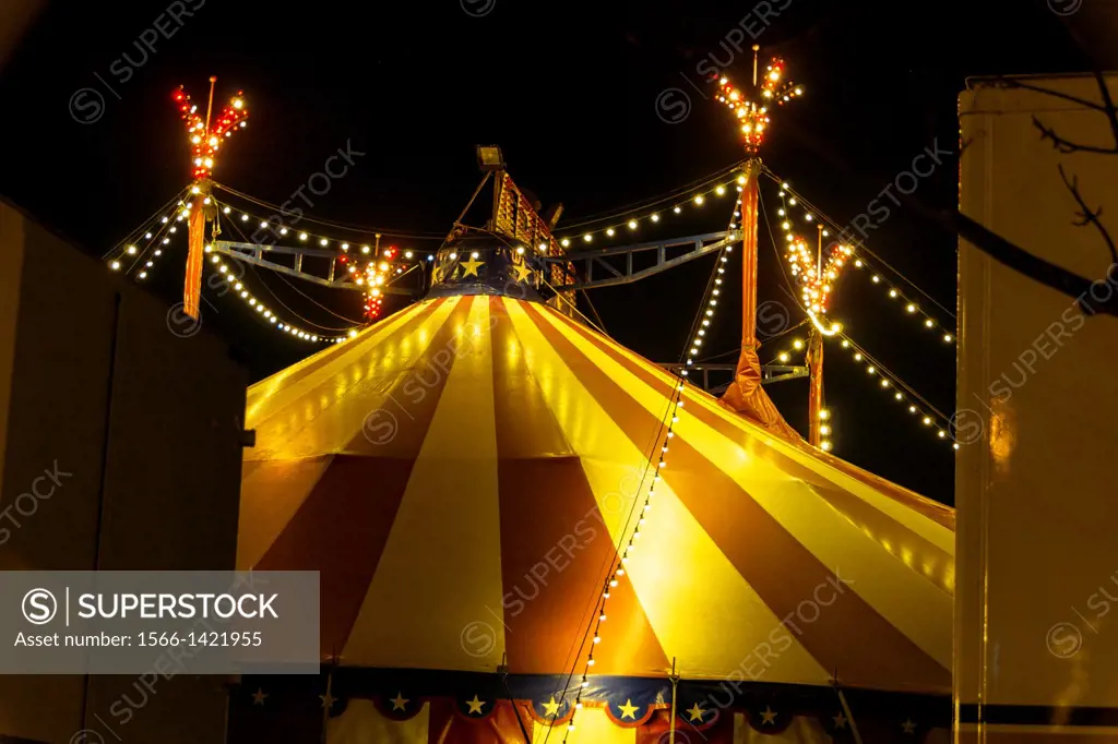 An illuminated big top at night with the nigh sky at background.