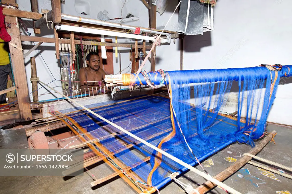 Man weaving sari on handloom, Odisha, India.