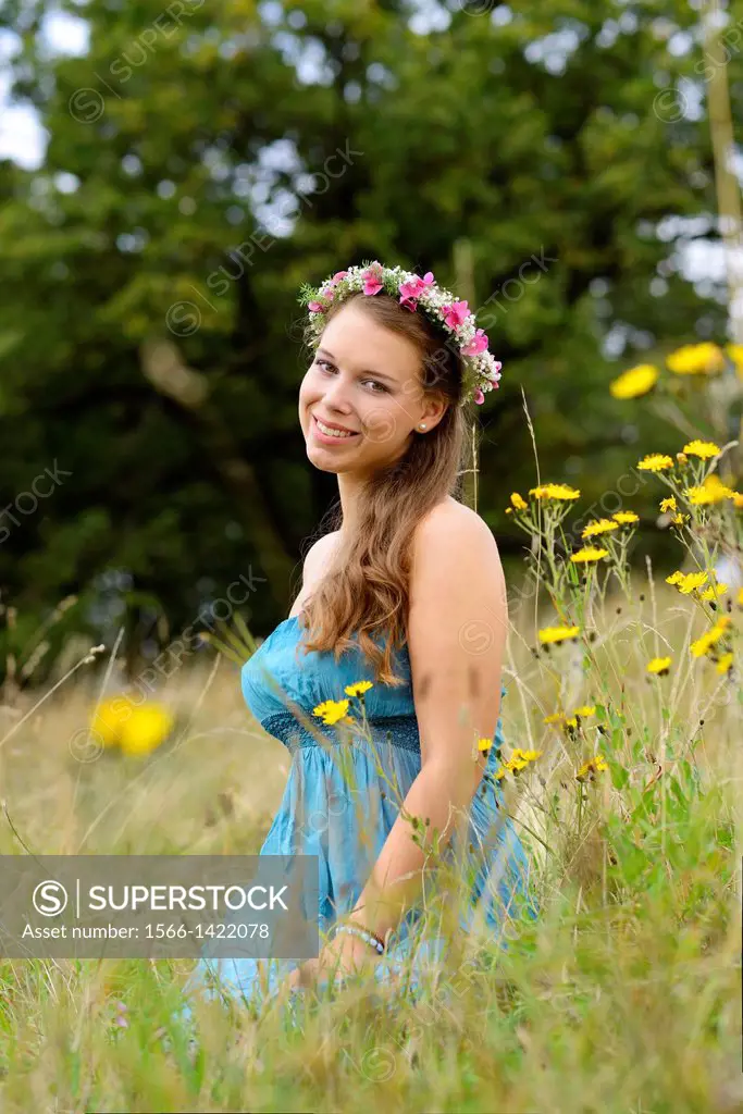 Young woman with a floral wreath in her hair outdoors, Germany.