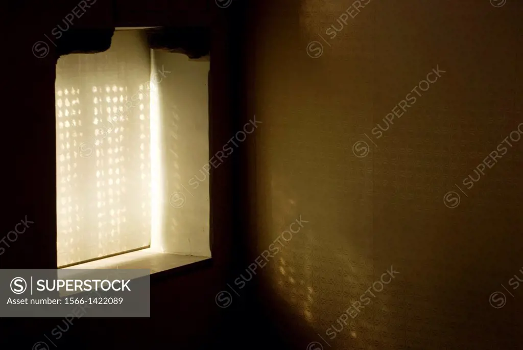 Window with lace curtain and latticework showing a veiled light and wall covered with hangings, Synagogue of El Transito, Toledo, Castilla La Mancha, ...