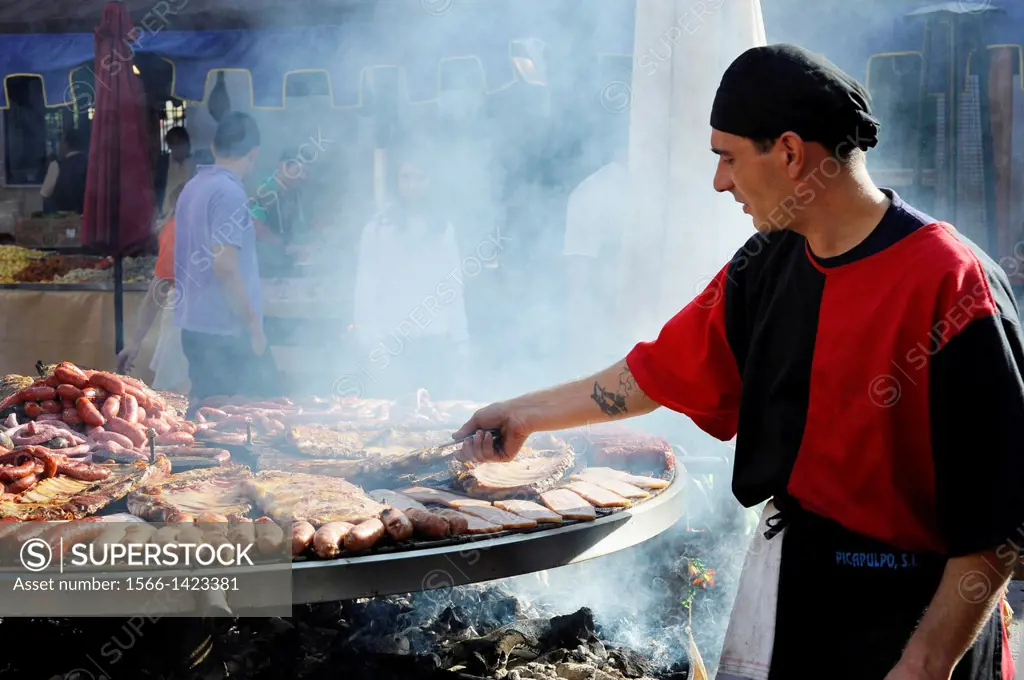 cook handles giant barbecue in the annual All Saints Market in Concentaina, Alicante province, Spain.
