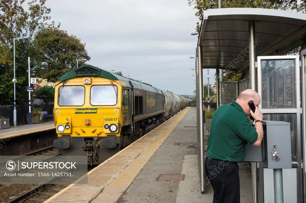 Freightliner train driver calling signal box from Seaham station on the East Coast line in north east England, United Kingdom.