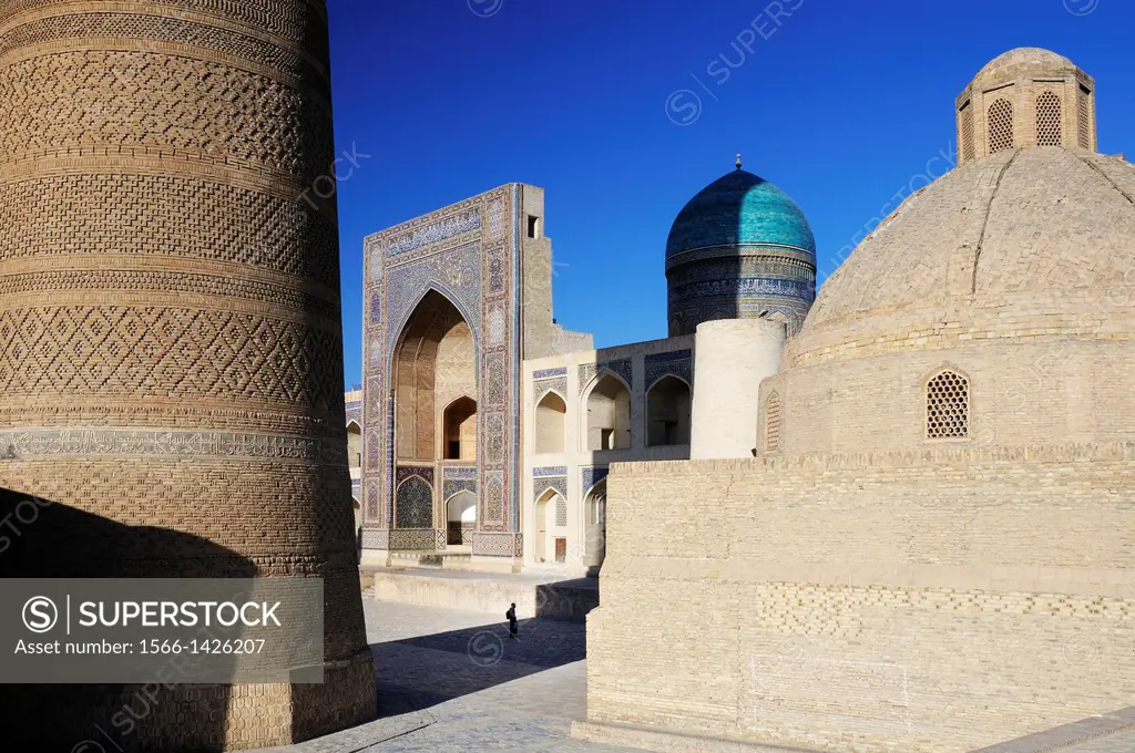 Silhouette in front of Mir-i-Arab Madrasa with Kalon minaret in the foreground. Uzbekistan, Bukhara.