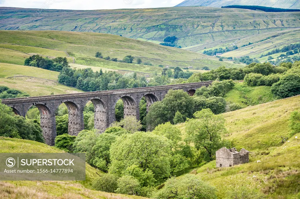 Extensive stone bridge allows for trains to cross over rolling hills of the Dales, Yorkshire Dales, UK.