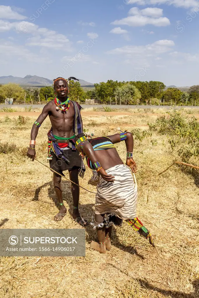 A Hamar Tribesman Whipping Young Hamar Women. The Young Women Ask