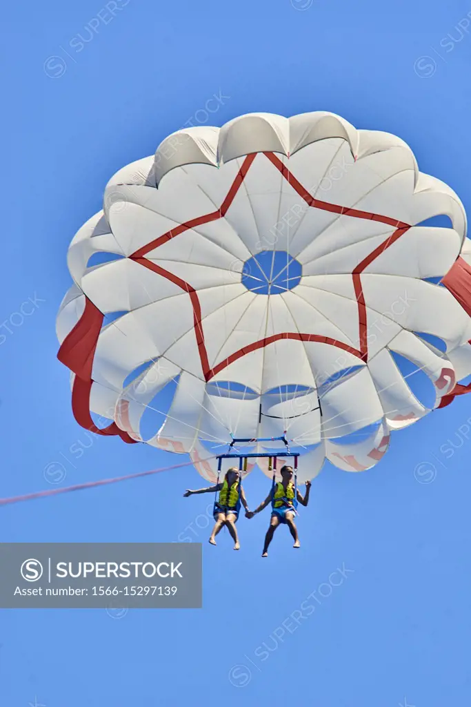 Couple during parasailing adventure, flying in sky. Chersonissos. Crete, Greece.