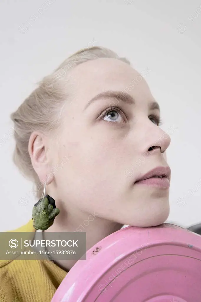 young woman wearing earrings made of raw zucchini