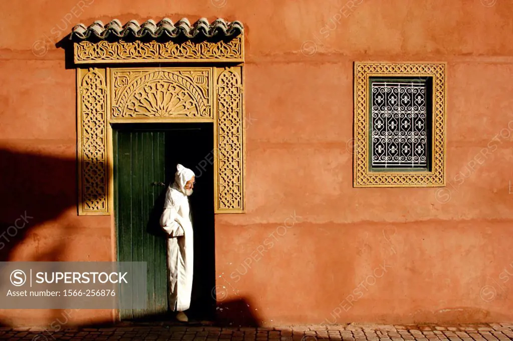 A man stand in front the entrance of a local house, Marrakech, Morocco