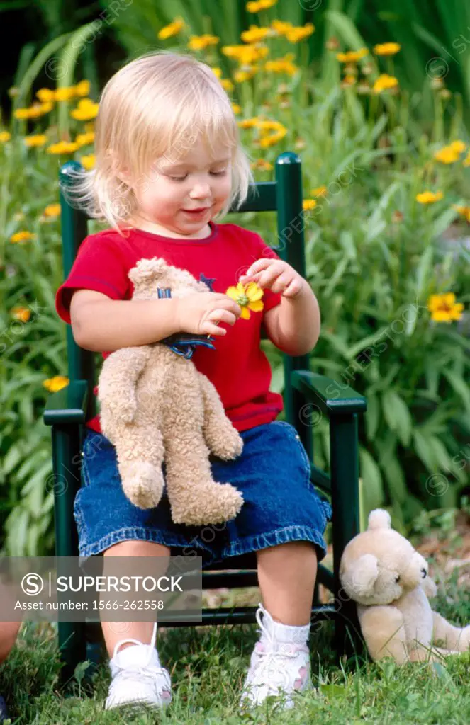 Little girl sitting in chair with her teddy bear