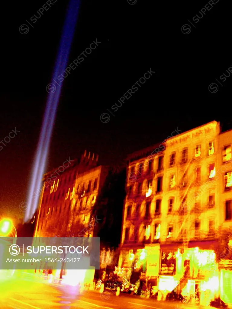 Ground Zero´s freedom lights can be scene shining over 1st Avenue in New York´s East Village.  Long time exposure blurs the buildings, giving the scen...