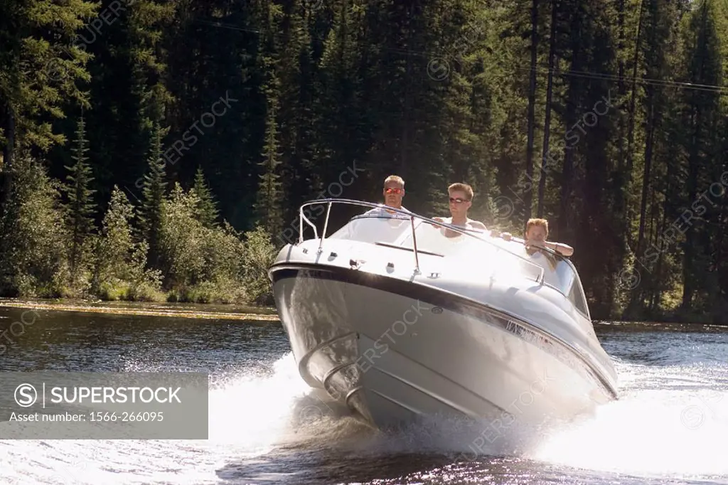 A man and two teenage boys in a Bayliner 212 on Gillette Lake, Washington State, USA