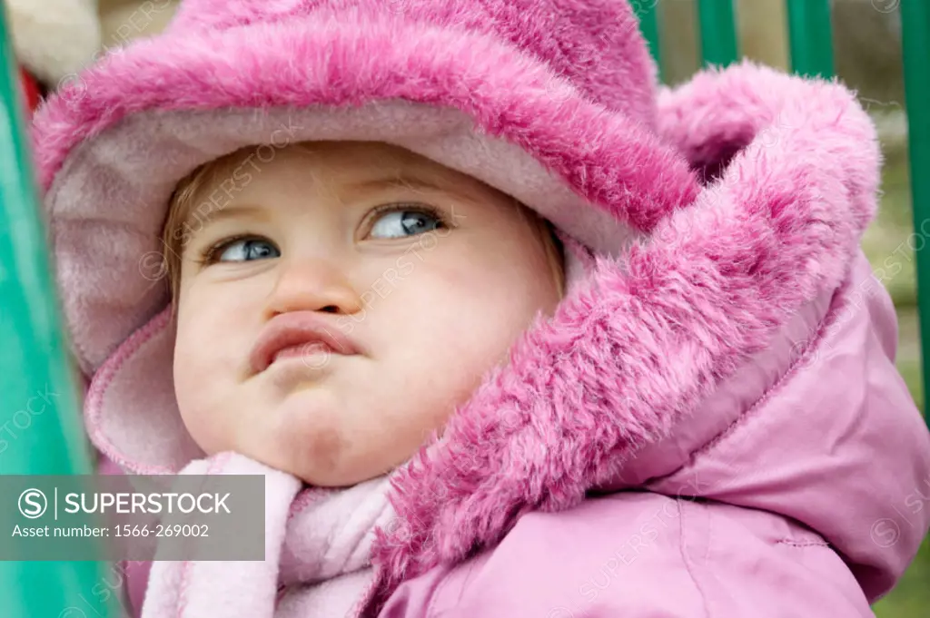 Headshot of a 20 month old girl pulling a funny face