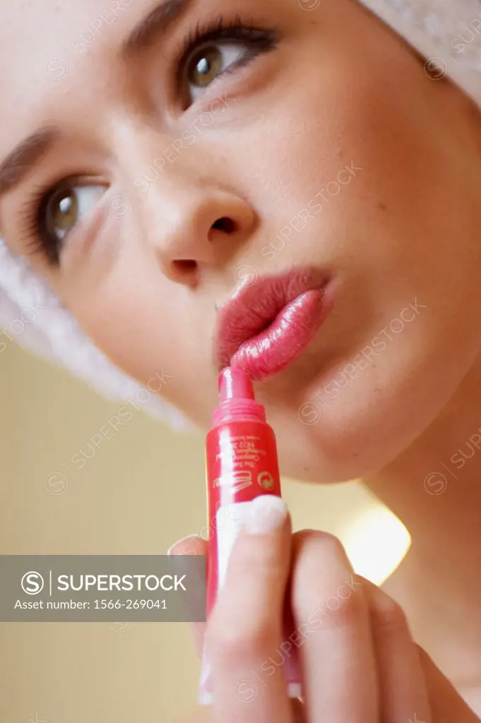 close up of woman about apply red lipgloss