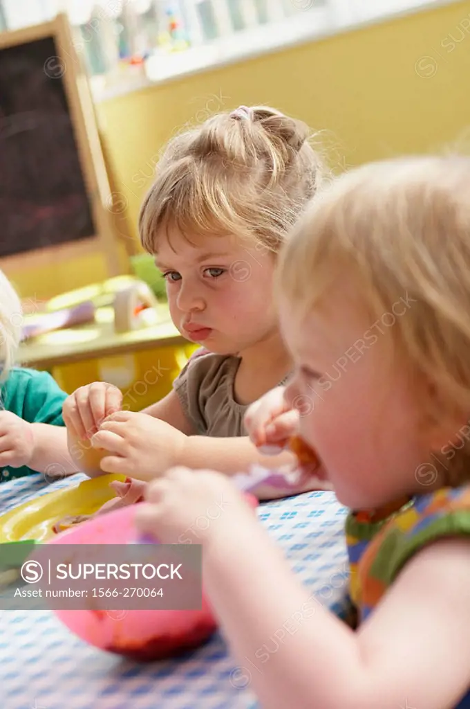 Children sitting eating lunch at nursery.