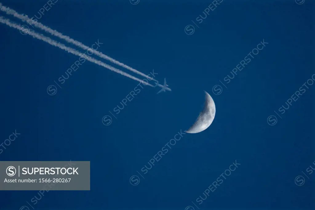 Flying plane just passing ower the moon.