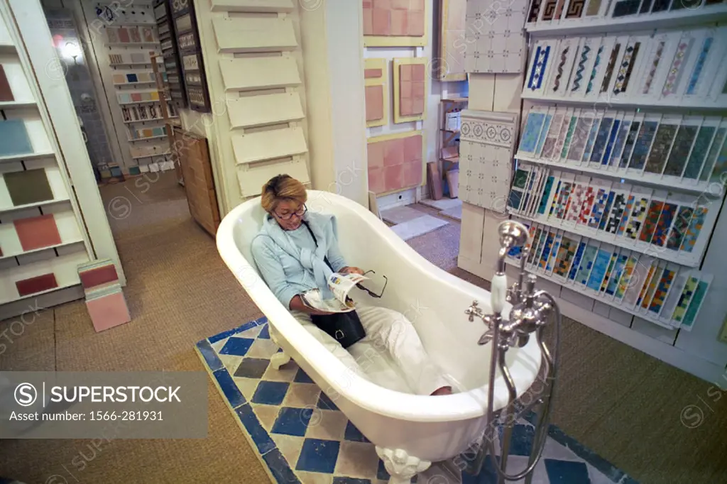 Woman shopping for a bath in a showroom. Rennes, Brittany, France