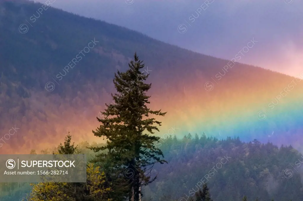 Rainbow over mountain slopes, Vancouver Island scenic. Chemainus, BC, Canada