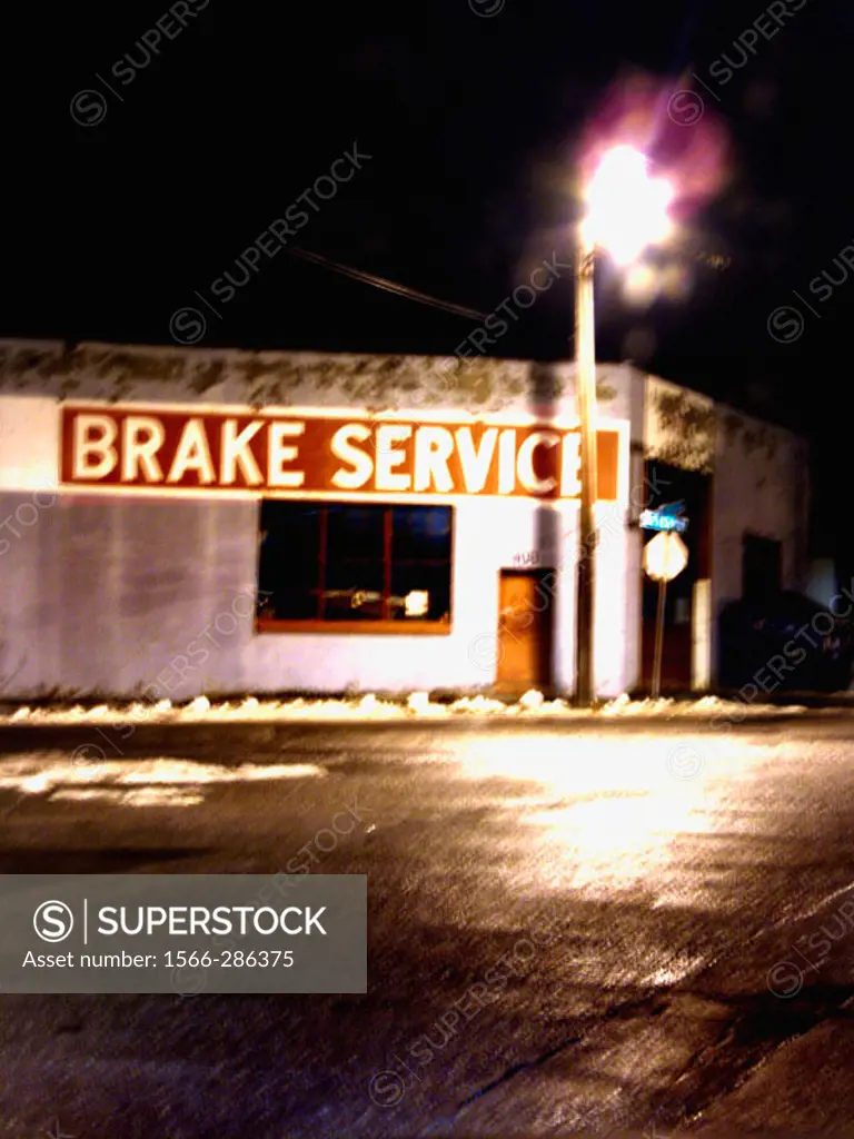 An automobile brake service shop in Albany, New York is captured at night with a slight blur.