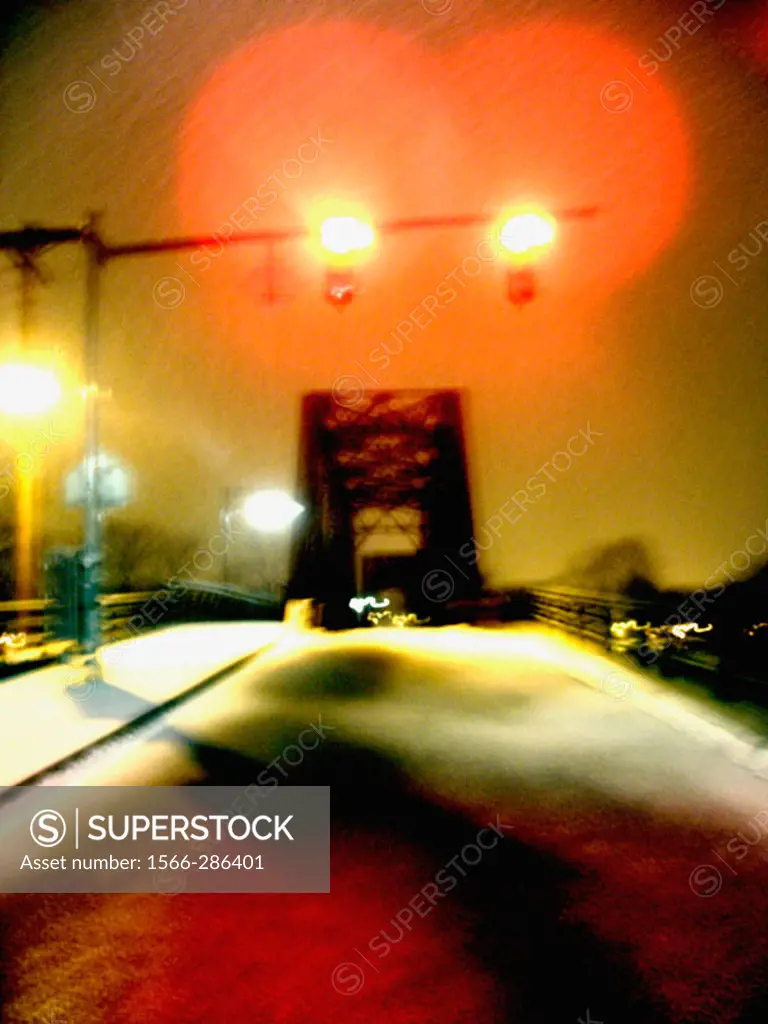 A train trestle is captured at night during the winter with fresh fallen snow.  Ghostly and mysterious.