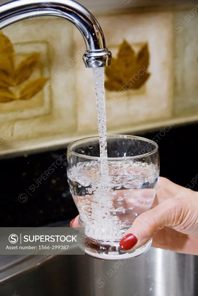 Glass of water being poured into a glass for drinking