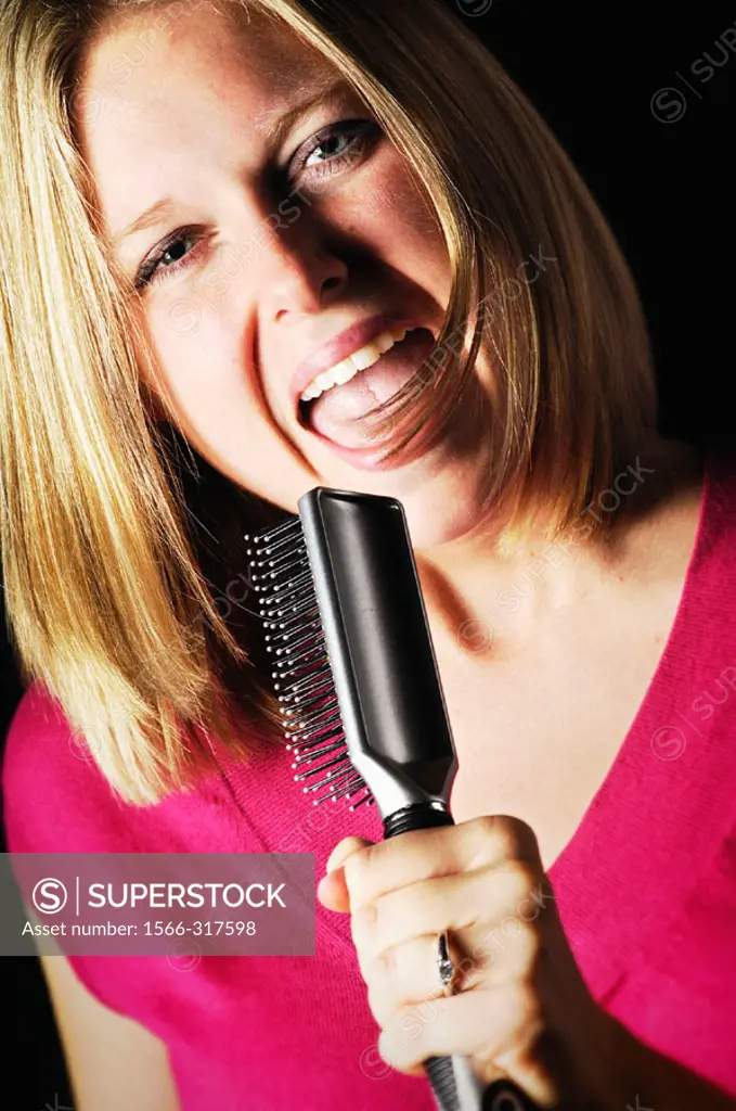 Woman singing into hair brush