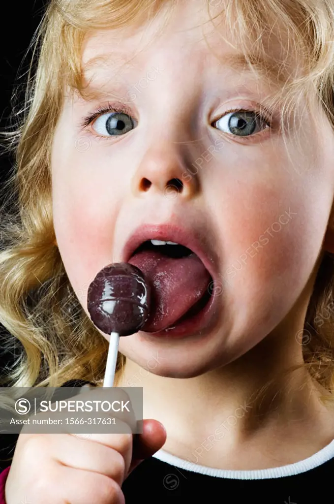 Little girl licking a sucker