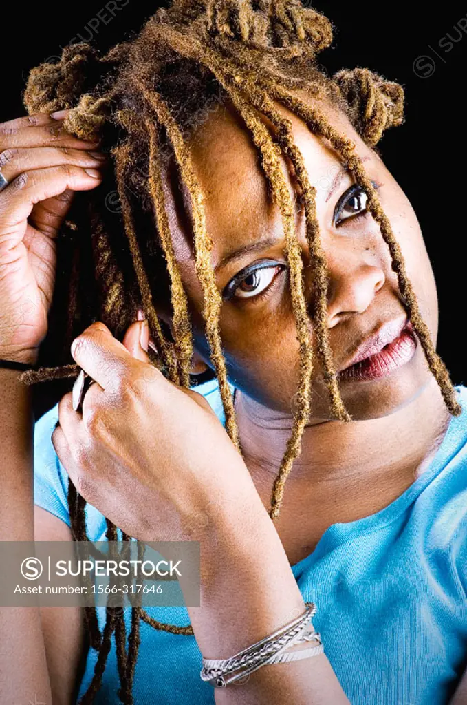 Black woman braiding her hair