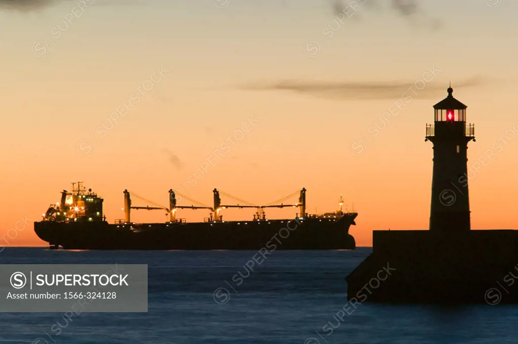 Duluth Harbor. Shipping Channel Lighthouse at Dawn with Freighter. Duluth. Minnesota. USA.