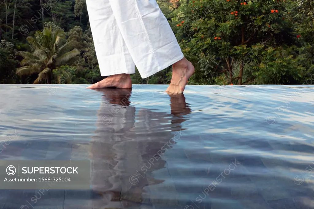 Man´s feet on the edge of an outdoor pool at Losari Coffee Plantation in West Java, Indonesia, South East Asia