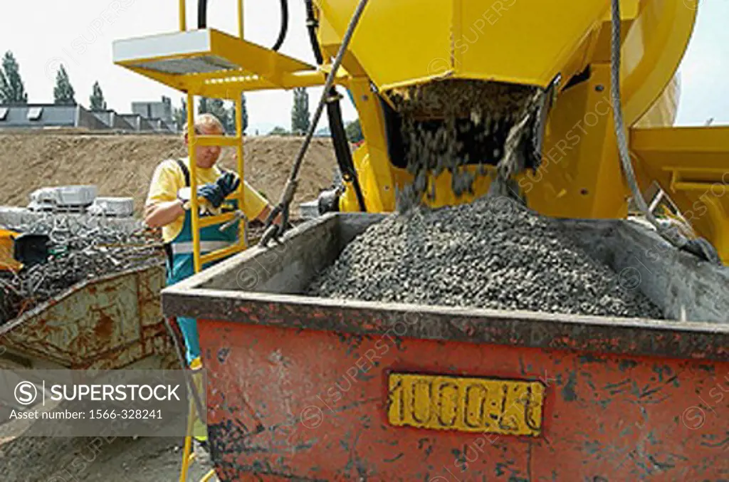 Construction worker fill concrete in a tub at construction site in Switzerland