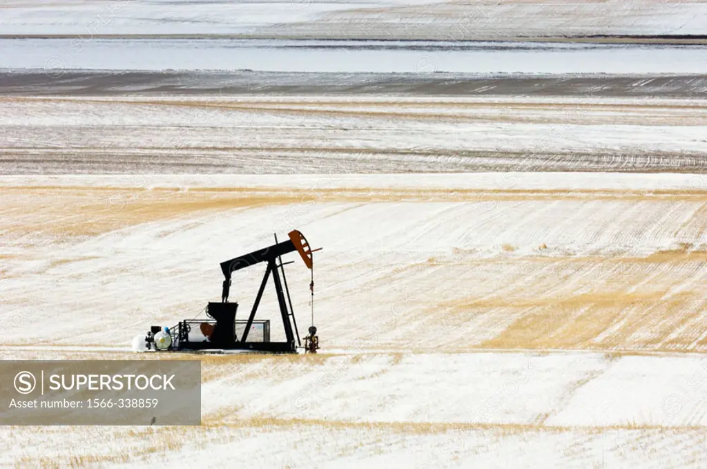 Oil well pump ´jack´ in snowy prairie. Alberta, Canada