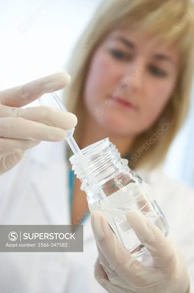 Technical staff taking samples of chemical solution. Laboratory, Fundación Inbiomed, Genetrix Group. Center for research in stem cells and regenerativ...
