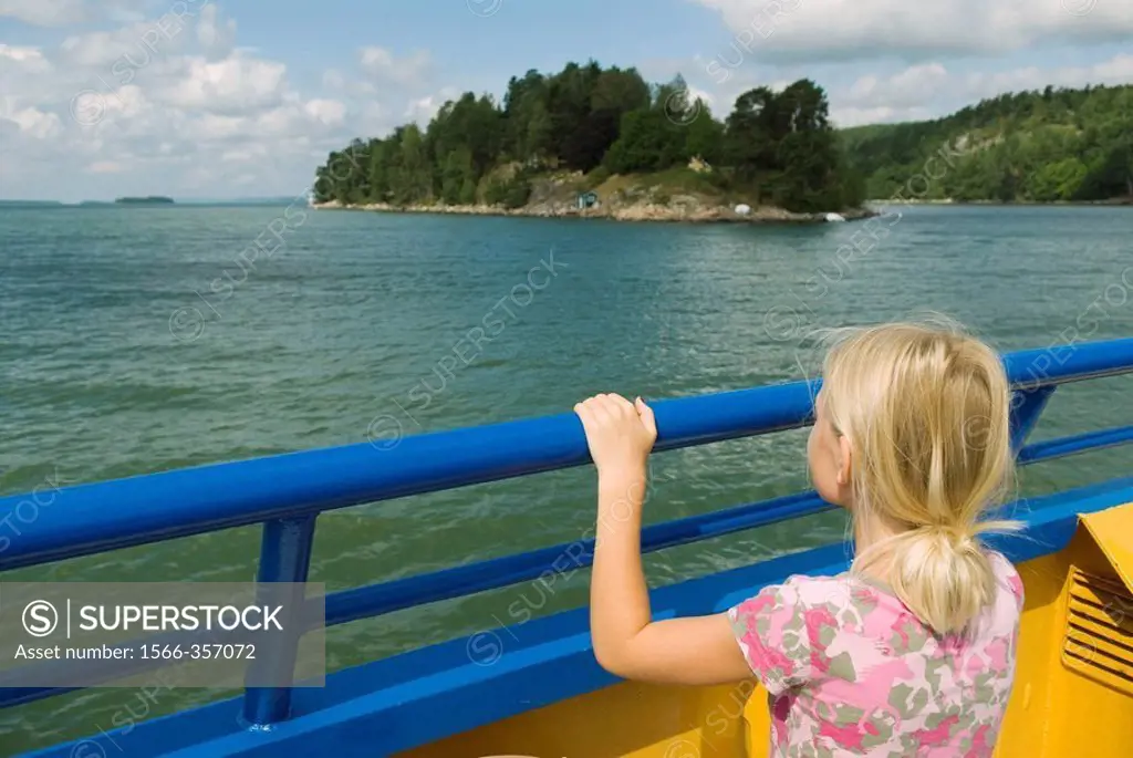 Girl watching the islands from a small car ferry. Sweden.