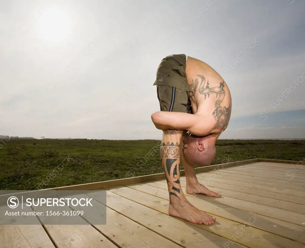 Man Stretching on a Wooden Platform