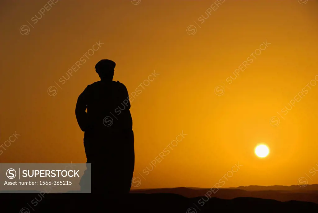 Omani man on the dunes, watching the sunset, northern edge of the Wahiba Sands, Oman