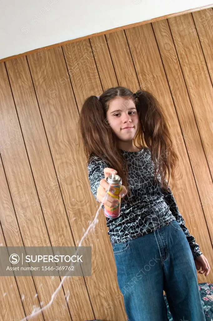 Preteen girl, with two large ponytails, squirting liquid string.