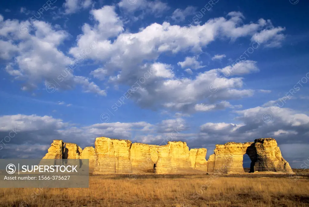 Once buried beneath an ancient sea, Monument Rocks rises from the plains below a sky filled with cottonball clouds, Kansas, USA.