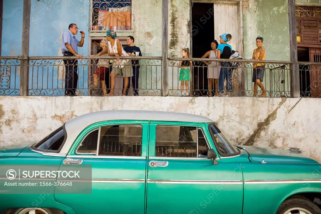 House and family in the town centre. Old car. Santiago de Cuba, Cuba