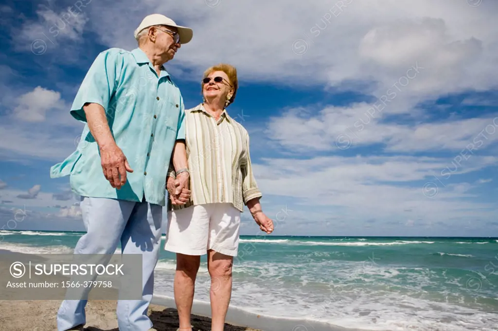 Senior couple strolling along beach