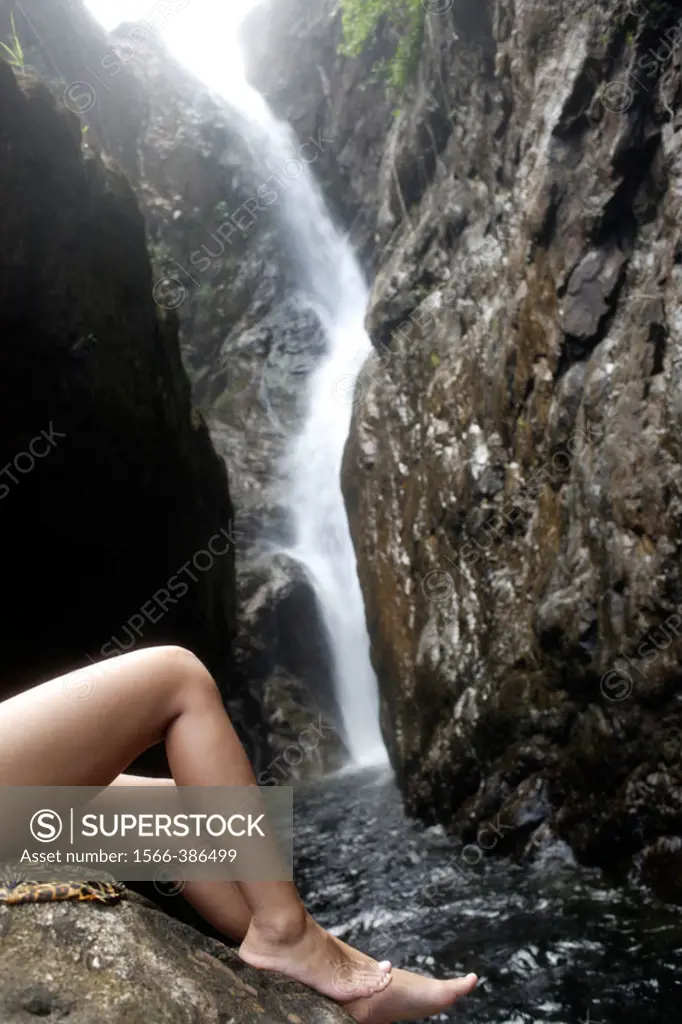Nacked woman´s legs on a rock near Khlong Phu waterfall at narrow gorge, Kho Chang (Chang Island), Trat Province, Thailand, Southeast Asia