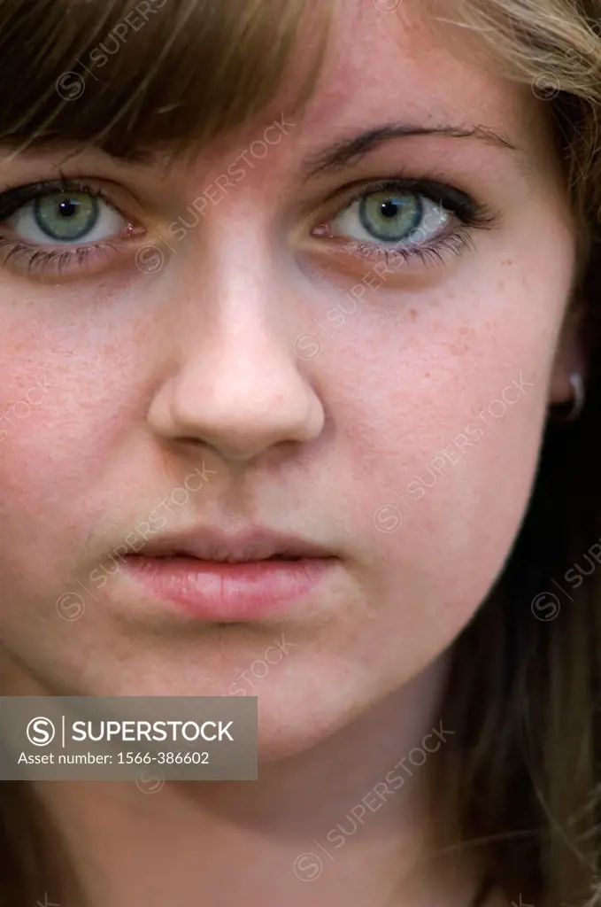 The face of a teen with blue eyes looking towards the camera