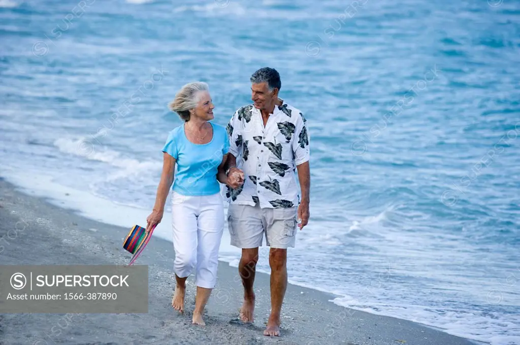 senior couple strolling along the beach