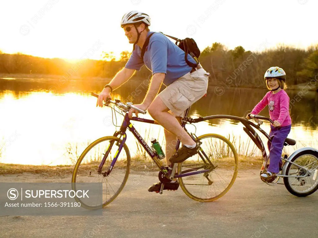 Father and daughter riding ´tandem´ bicycle.