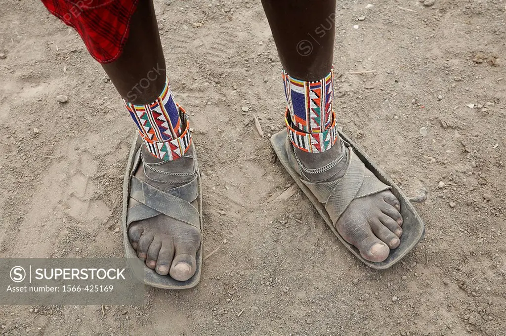 Detail of sandals made from car tires and ankle ornaments worn by a Masai warrior, Masai village within the Amboseli National Park. Kenya