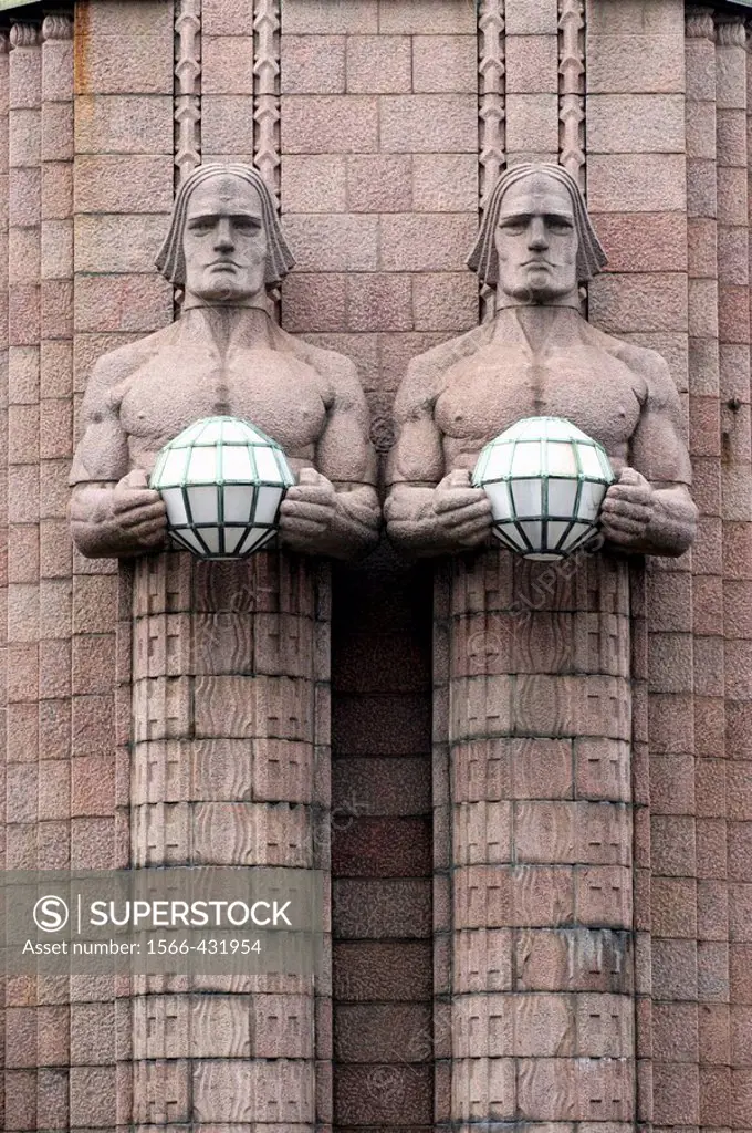Helsinki Central railway station. Built in 1860, designed by Eliel Saarinen. Statues of two men, each holding a sphere in their hands. These spheres a...