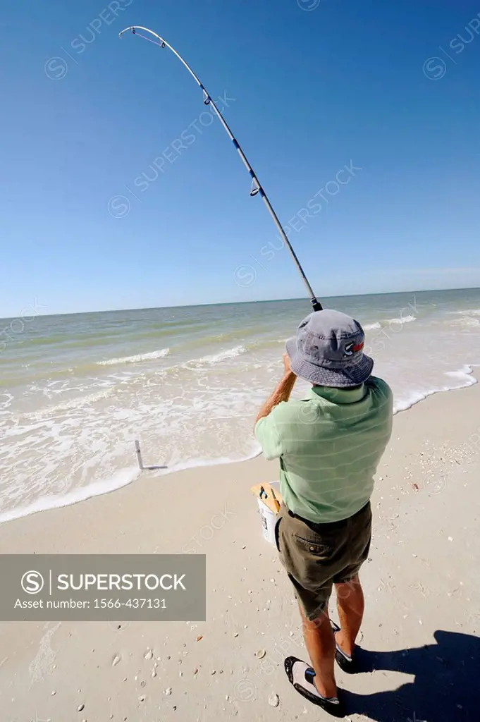 Senior man fishing for recreation in the Gulf of Mexico at Naples Florida