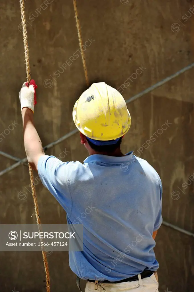Construction worker holding rope ready to hoist