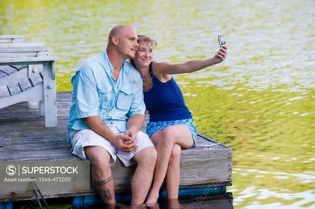 couple on dock taking photo with camera phone